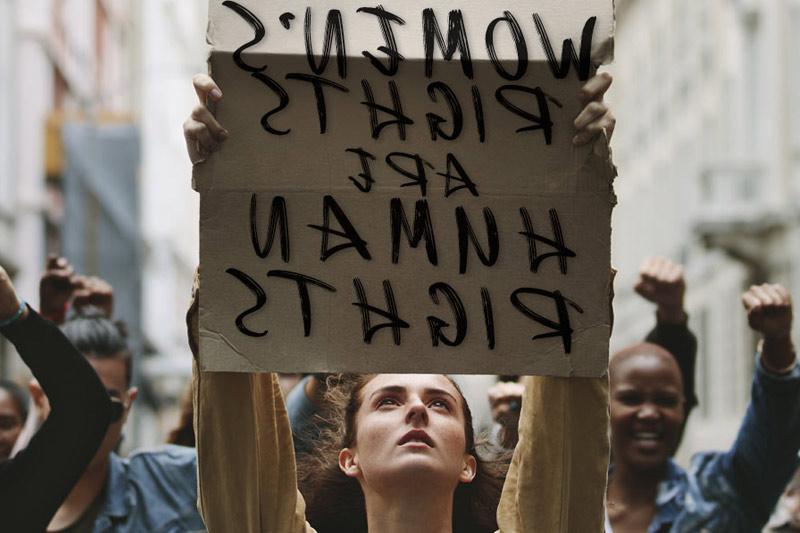 Photo of Woman holding poster that states "Women's Rights are Human Rights"