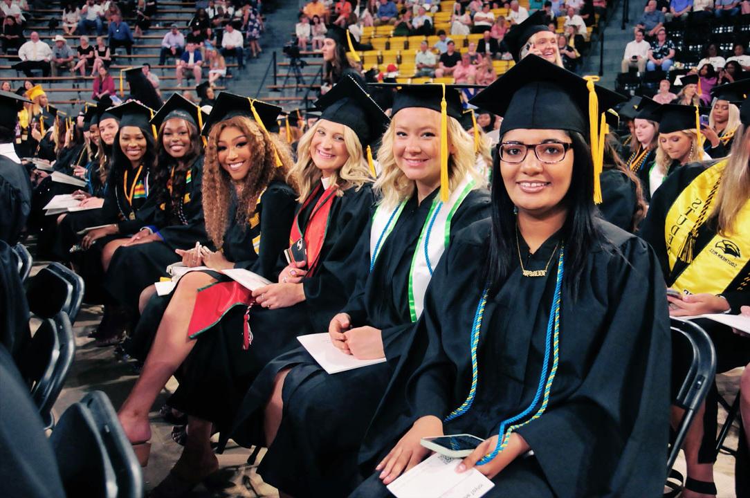 Graduates smile as they await commencement to begin